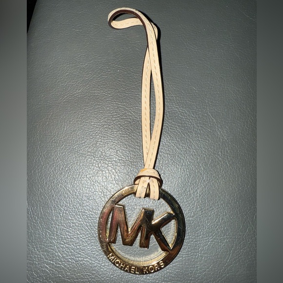 Michael Kors Accessories - Michael Kors Gold Tone MK Logo Charm With A Light Tan/Creme Color Leather Tassel